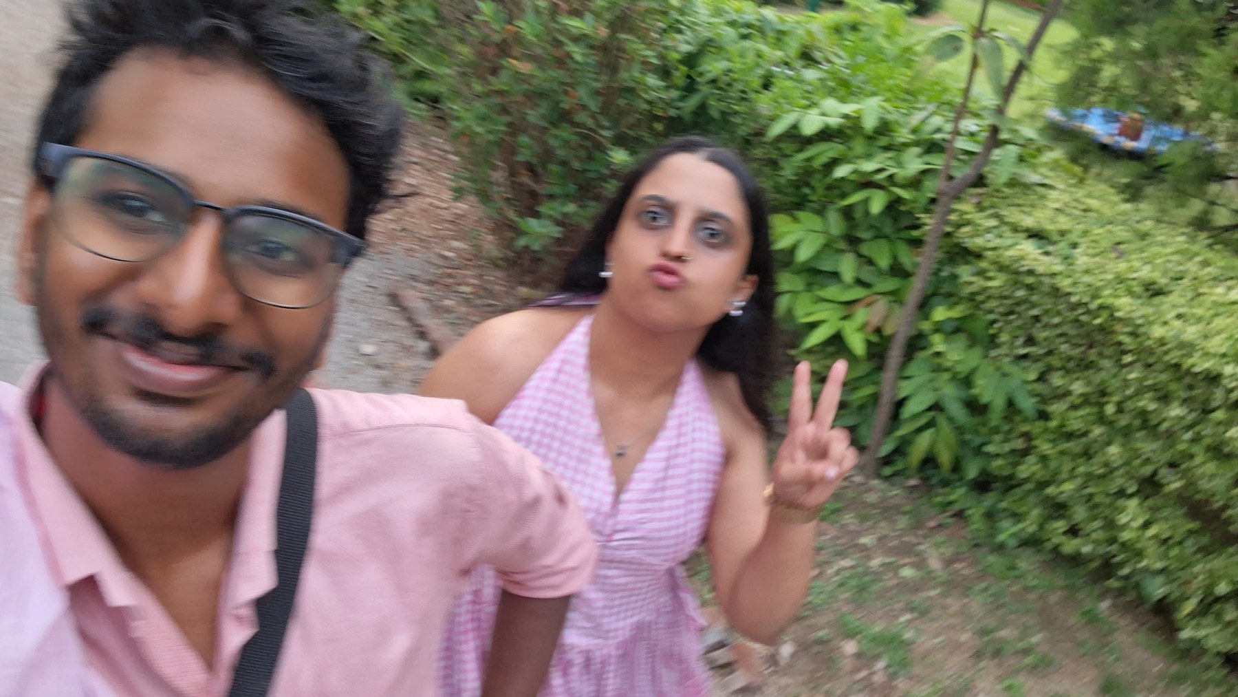 Lenal and Bhavna taking an outdoor selfie in matching pink outfits